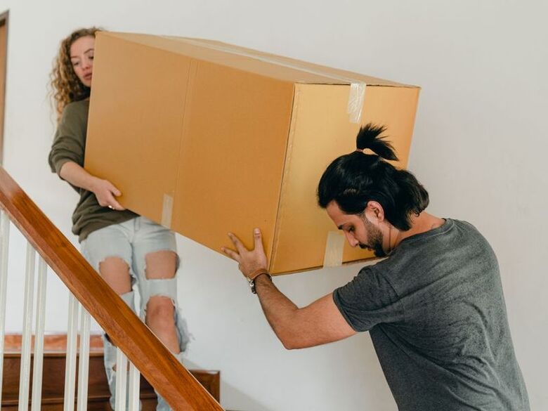 Mt Auburn Piano Movers wheeling a wrapped piano into a climate-controlled storage room